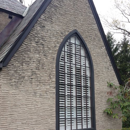 outdoor face of stone home with plantation shutters